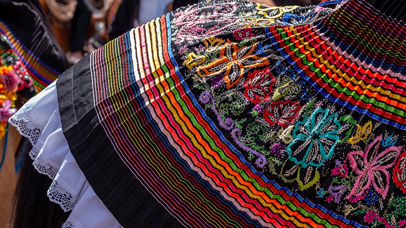 Colorful skirt of a woman riding a horse for the flower festival in Colombia. Carnival and party cheerful colors.